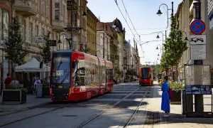 Czerwony tramwaj na ulicy w Katowicach, gdzie można podziwiać wiele atrakcji. Słoneczny dzień zachęca do spacerów.