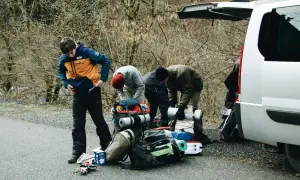Przygotowania do wyprawy w Tatry w listopadzie. Grupa ludzi pakuje sprzęt turystyczny przy otwartym bagażniku białego vana.