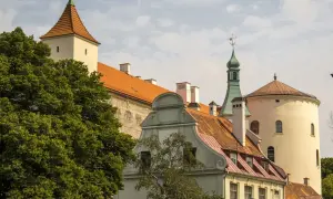 Historyczne budynki, w tym wieża i okrągła baszta, tworzą malowniczy krajobraz. Wśród nich znajduje się dom bractwa czarnogłowych.