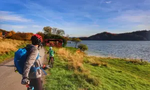 Rodzina na rowerach podziwia jesienne krajobrazy nad jeziorem. Trasa velo Czorsztyn GPX zapowiada się wspaniale!