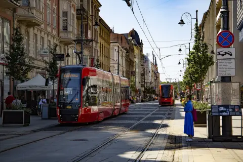 Czerwony tramwaj na ulicy w Katowicach, gdzie można podziwiać wiele atrakcji. Słoneczny dzień zachęca do spacerów.