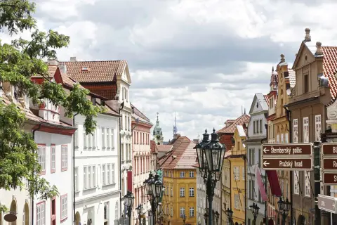 Urokliwa uliczka w Pradze, pełna kolorowych kamienic i zabytkowych latarni. Odkryj praskie nietypowe atrakcje, kierując się strzałkami do Zamku i Pałacu Sternbergów.