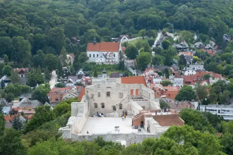 Ruiny zamku na wzgórzu otoczone jesiennymi drzewami.