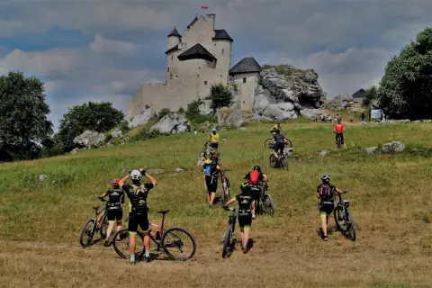Grupa rowerzystów zdobywa zamek na Jurze Krakowsko-Częstochowskiej.