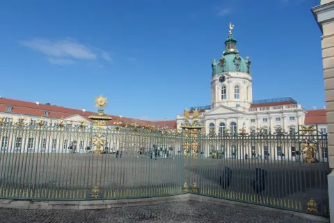 Zamek Charlottenburg, cel jednodniowej wycieczki z Poznania. Złote zdobienia bramy i błękitne niebo.