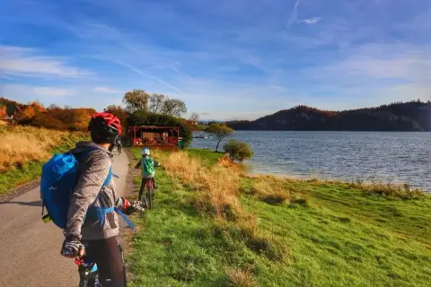 Rodzina na rowerach podziwia jesienne krajobrazy nad jeziorem. Trasa velo Czorsztyn GPX zapowiada się wspaniale!