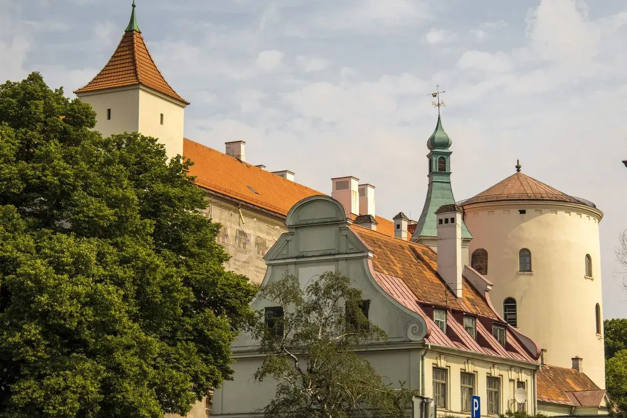 Historyczne budynki, w tym wieża i okrągła baszta, tworzą malowniczy krajobraz. Wśród nich znajduje się dom bractwa czarnogłowych.